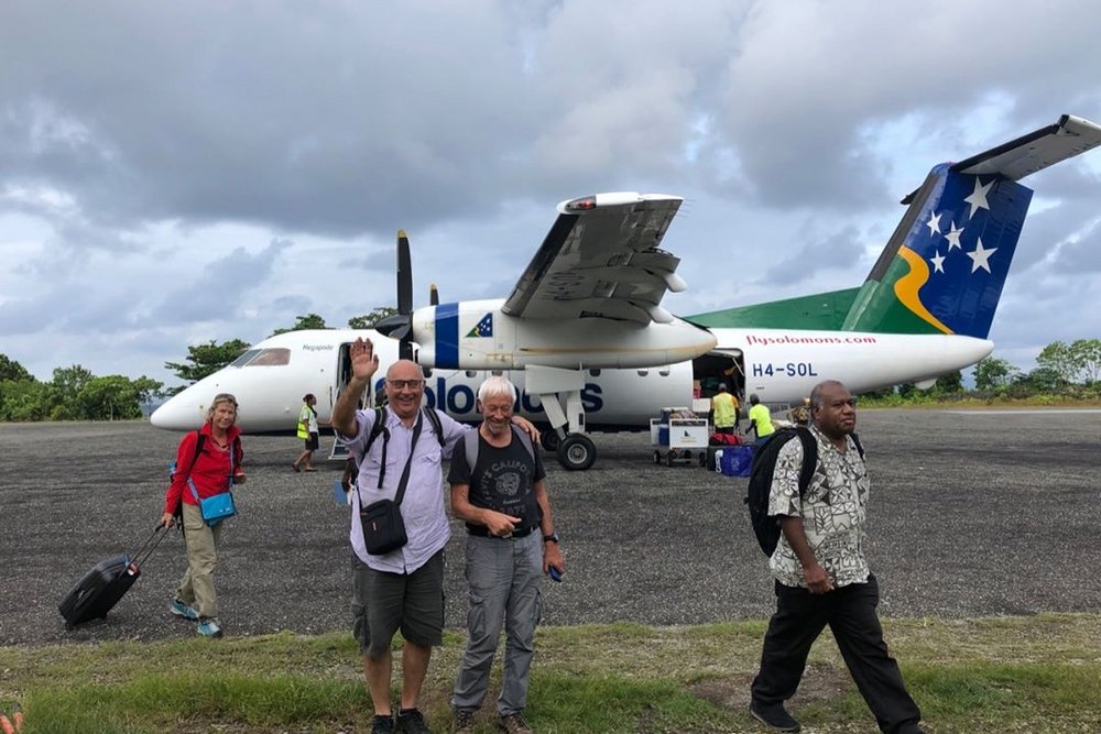 Gruppenfoto vor einem Flugzeug bei einer Tauchreise von TSK