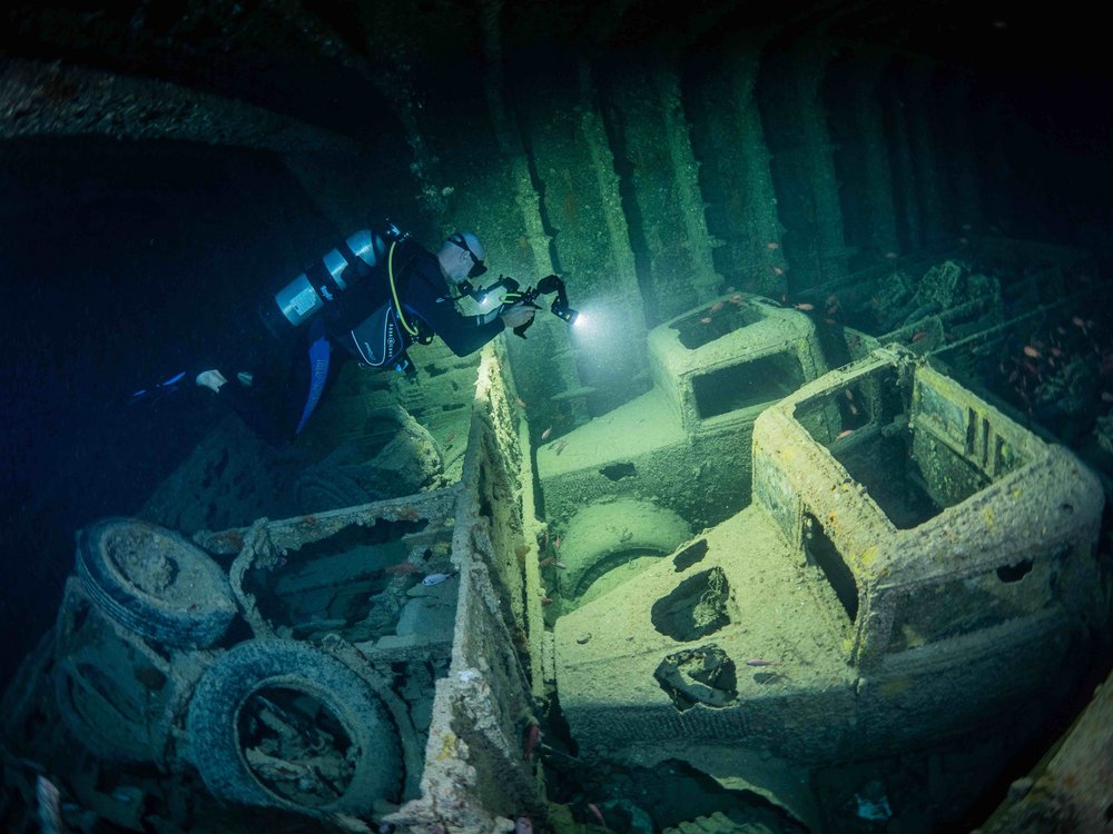 Foto von versunkenen Lastwagen, Taucher und Fischen